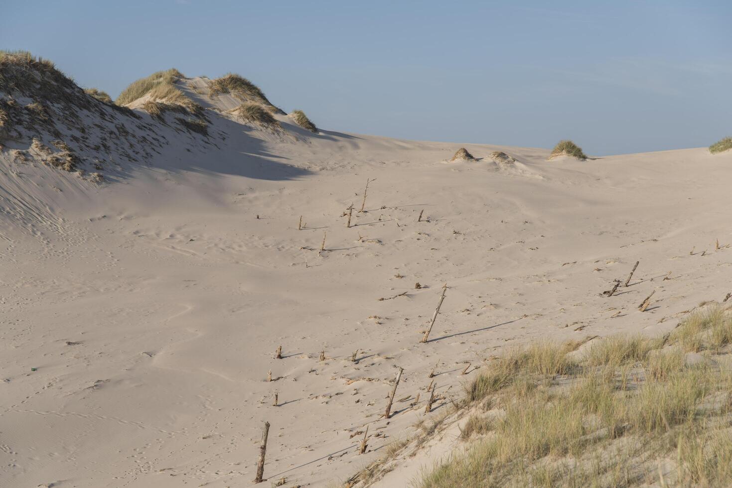 A sand dune with a fence around it photo