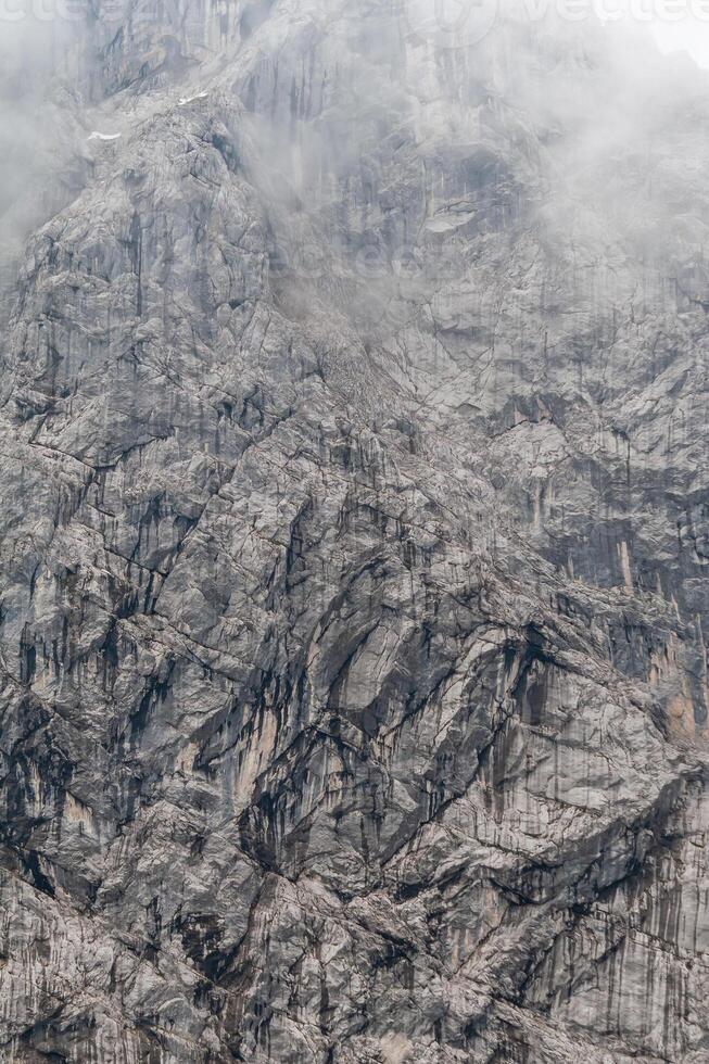 mountain wall - texture of a rock wall in the mountains with clouds photo