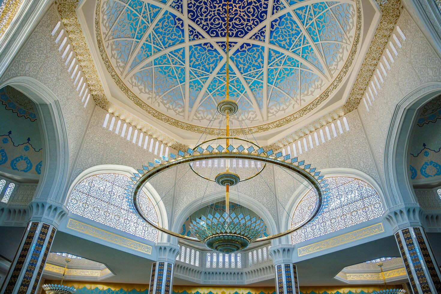 Astana, Kazakhstan - May 21,2025. Interior view of the dome and chandelier in the central mosque of Astana Kazakhstan. Ornate Islamic design with symmetrical patterns and architectural elegance. photo