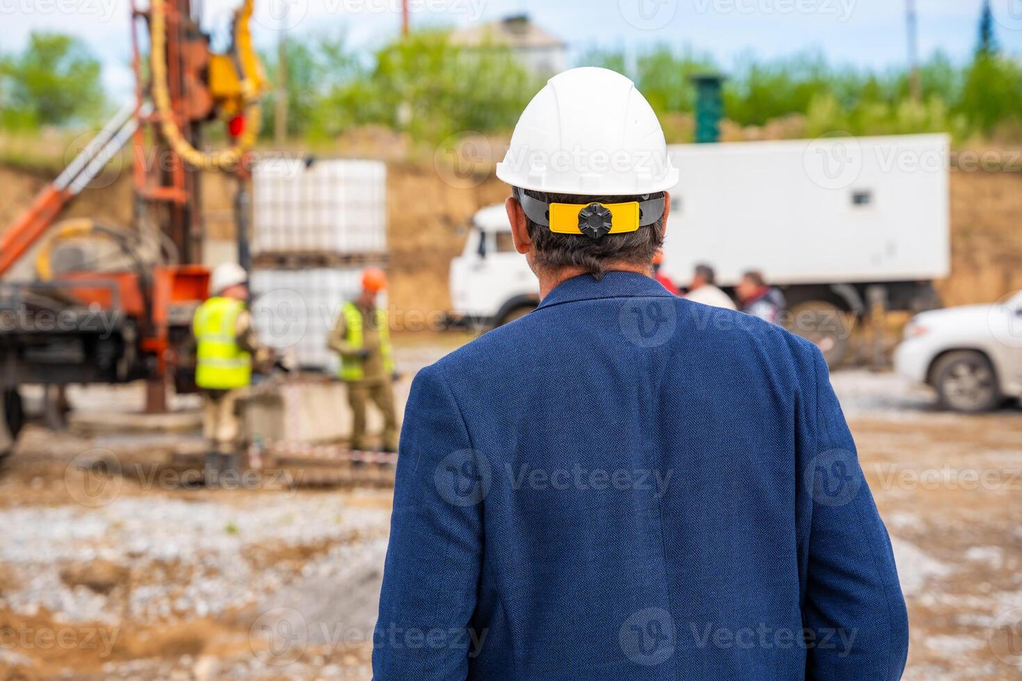 Supervisor overseeing soil sampling and pile drilling process on construction site. Responsible specialist ensuring quality control and compliance during geotechnical operations. High quality photo