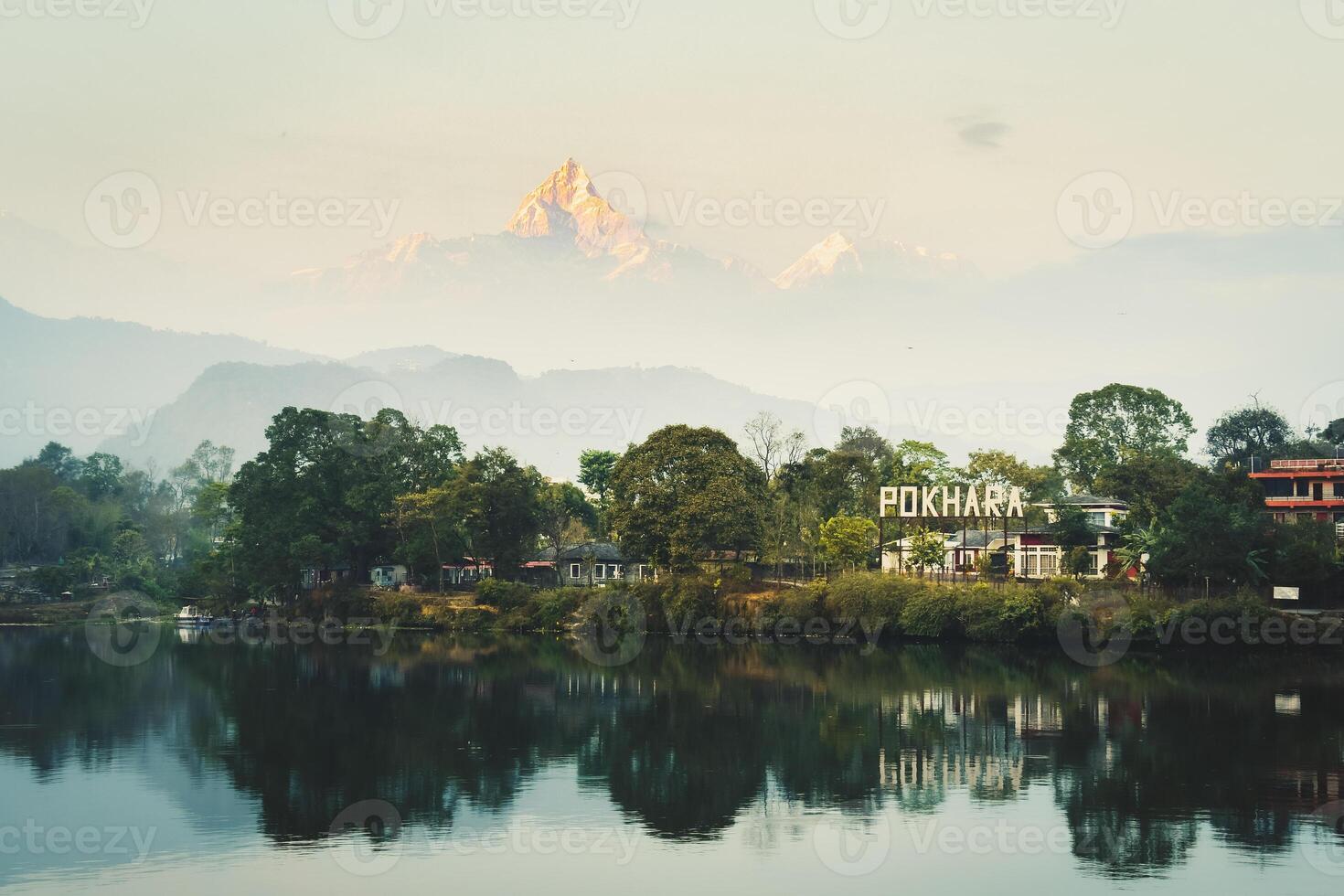 Annapurna mountain range reflection view on lake at sunset. Pokhara city and Phewa Lake, central Nepal. Annapurna mountain range snowy peaks photo