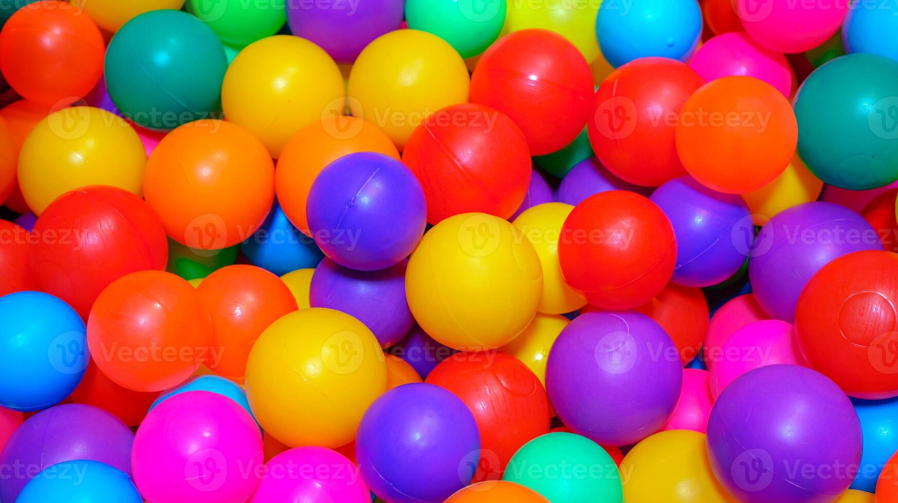 Many colorful plastic balls in pool of game room. indoors playground. photo