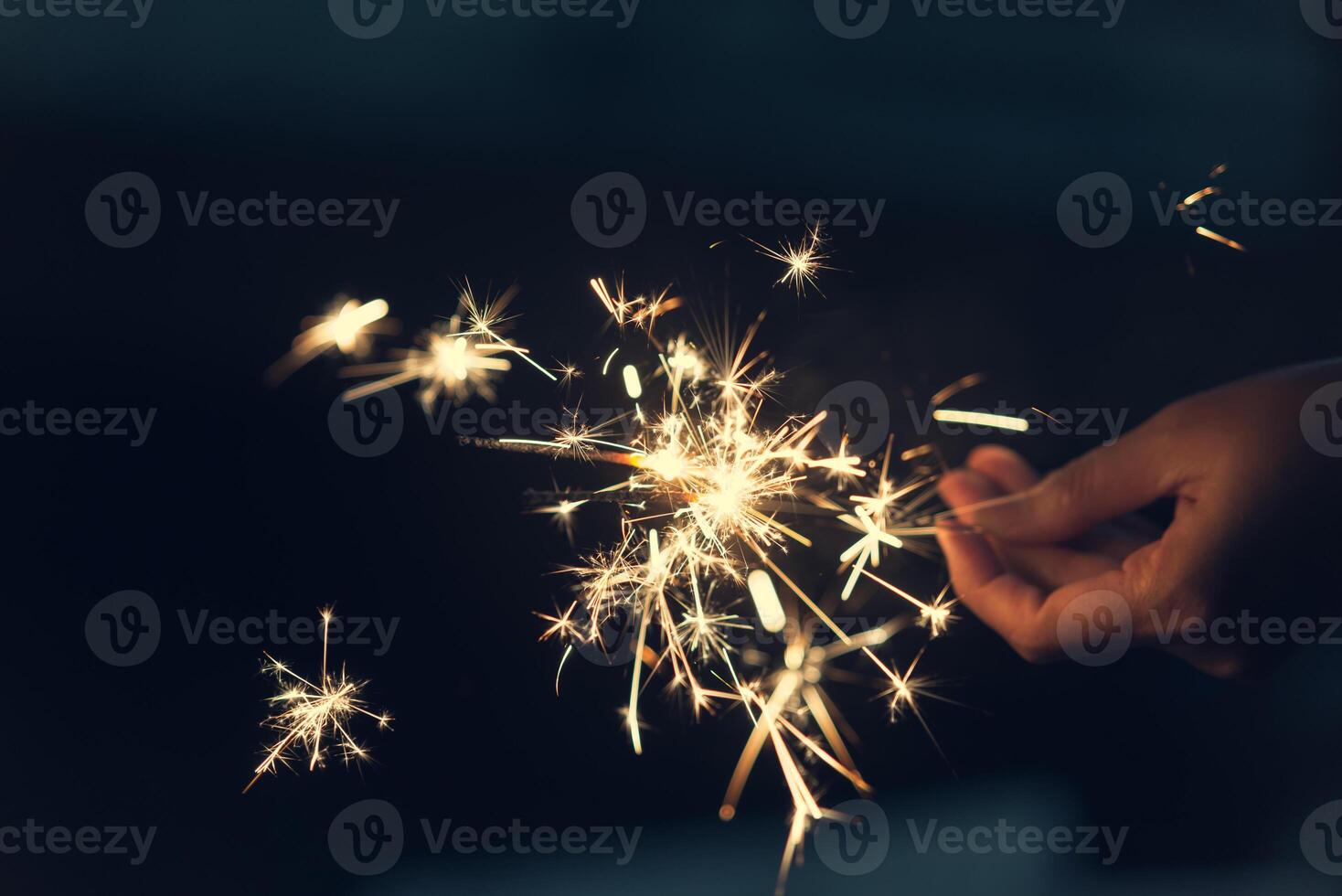 Female holding sparkler with night background photo