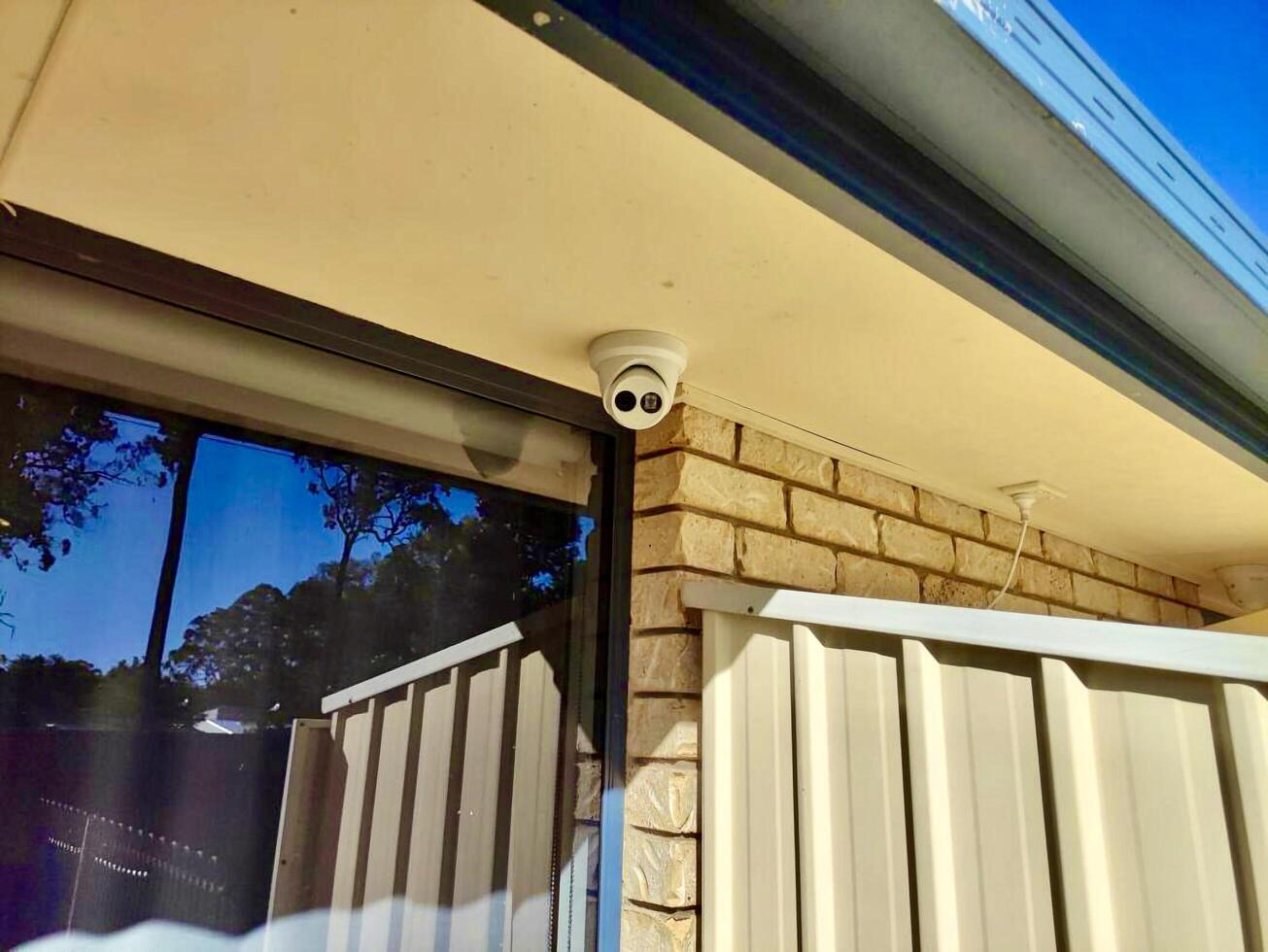 A camera is mounted on the side of a house photo