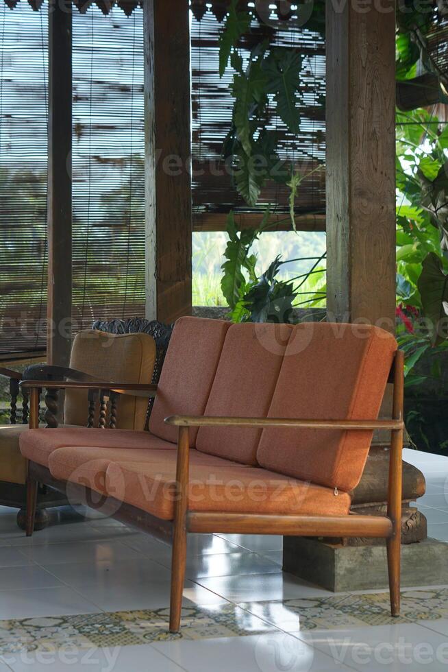 Vintage Sofa on Tiled Floor with Bamboo Screen and Lush Greenery View photo