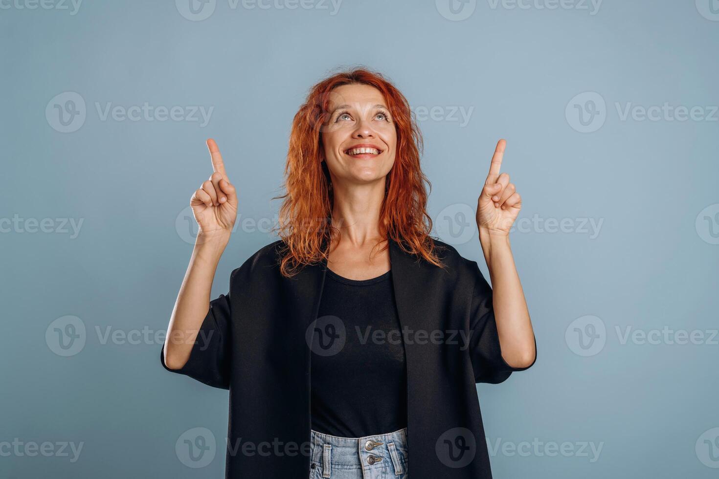 With fingers up, showing. Woman is in the studio against background photo