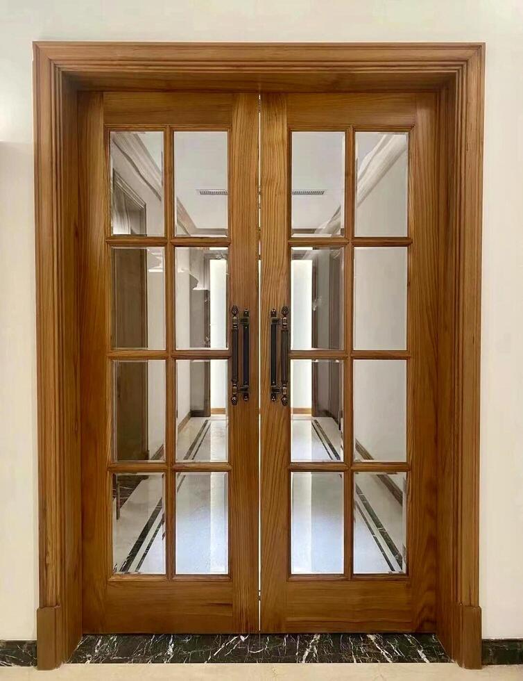 A wooden double door with glass panels photo