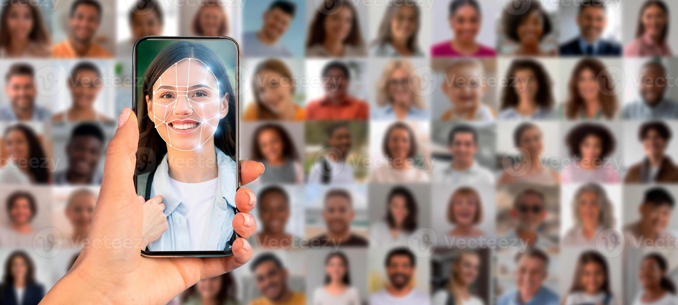 A hand holds a smartphone displaying a face recognition scan of a person. In the background, a collage of diverse faces emphasizes the application of identification technology today. photo