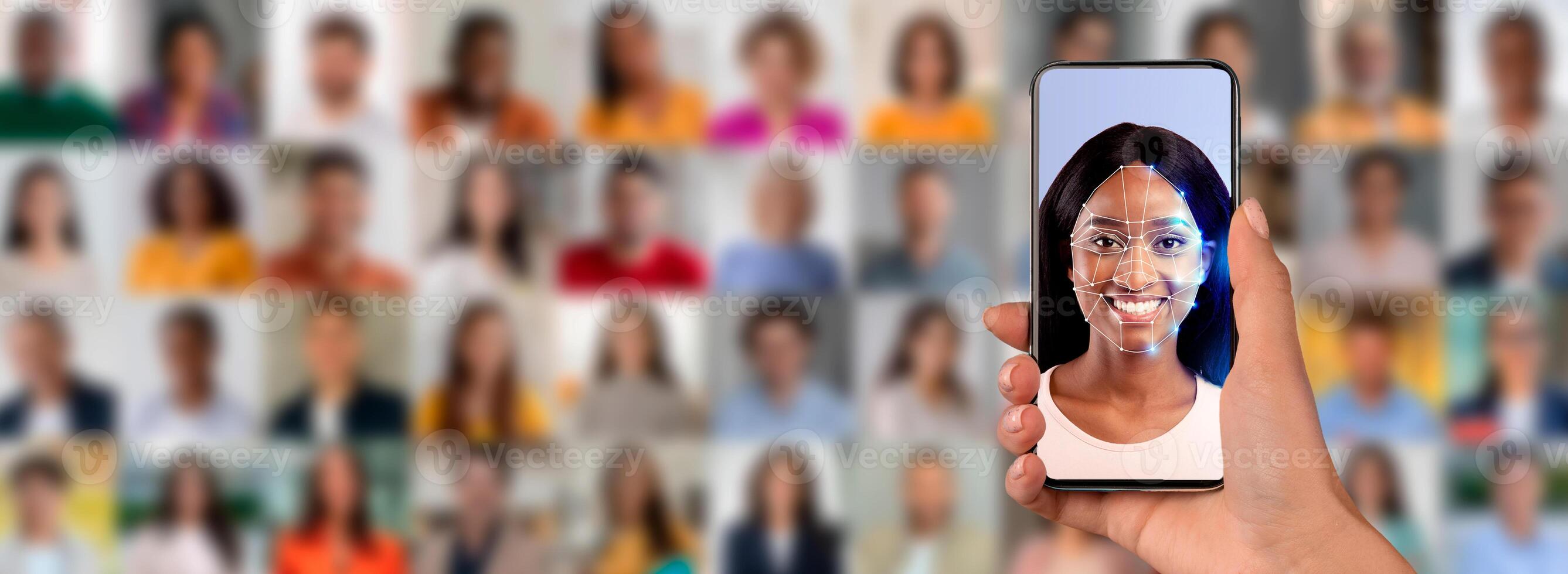A hand holds a smartphone displaying a smiling face with a digital overlay for identification. photo