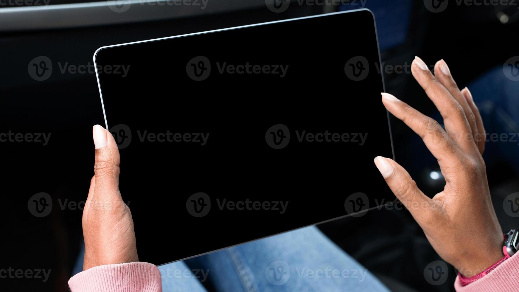 Modern remote work, online map, travel route in trip. Young african american lady holds tablet with empty screen in hands, surfing on internet and sits in car, cropped, pov, close up, free space photo