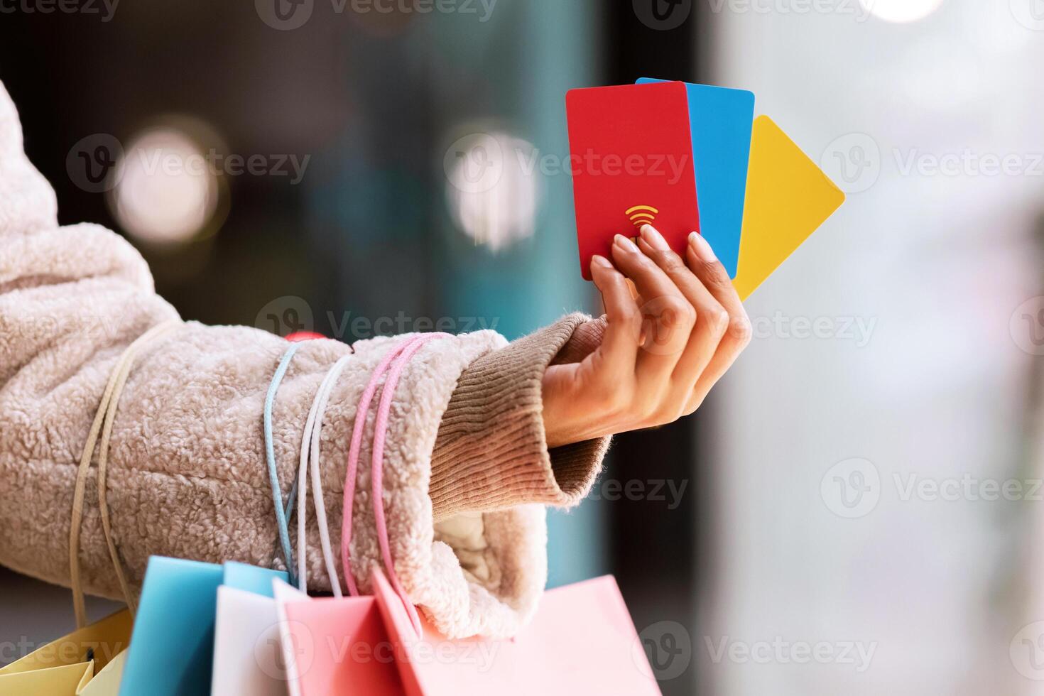 Spending Money, Discount Concept. Closeup Of Unrecognizable African American Woman Holding Three Colorful Credit Cards In Hand, Standing With Shopping Bags Outside Near MalL, Selective Focus photo