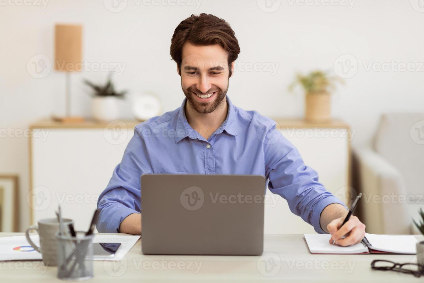 Successful Business Guy Working Writing Taking Notes Sitting At Laptop Computer In Modern Office. Professional Occupation, Entrepreneurship And Business Career Concept. Selective Focus photo