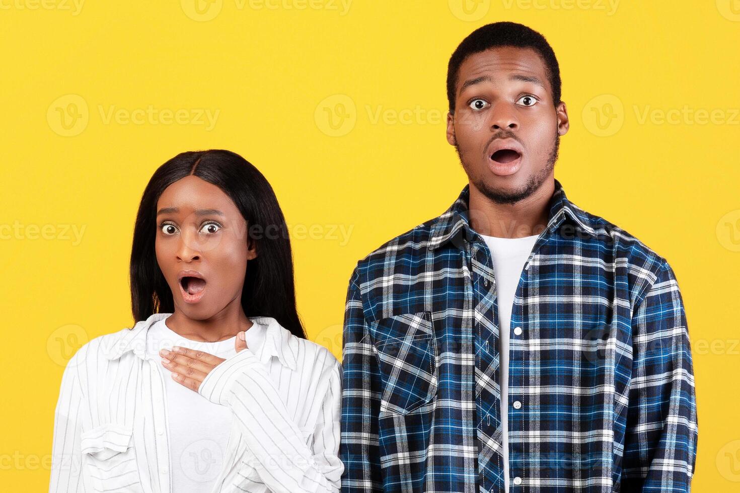 Human emotions, facial expression. Young frightened african american couple feeling terrified, suffering from fear or shock, with their mouths wide open, look at camera, have eyes full of disbelief photo