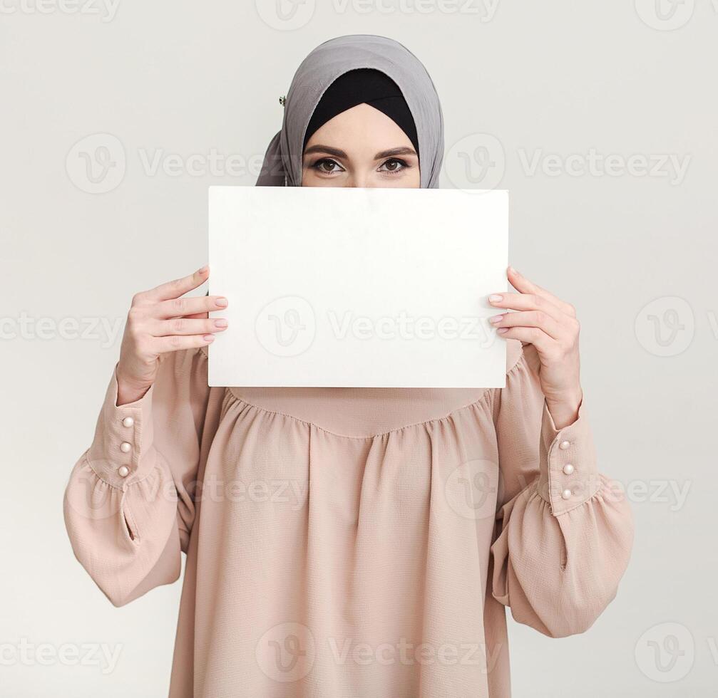 Advertising banner in hands of mislim woman in hijab photo