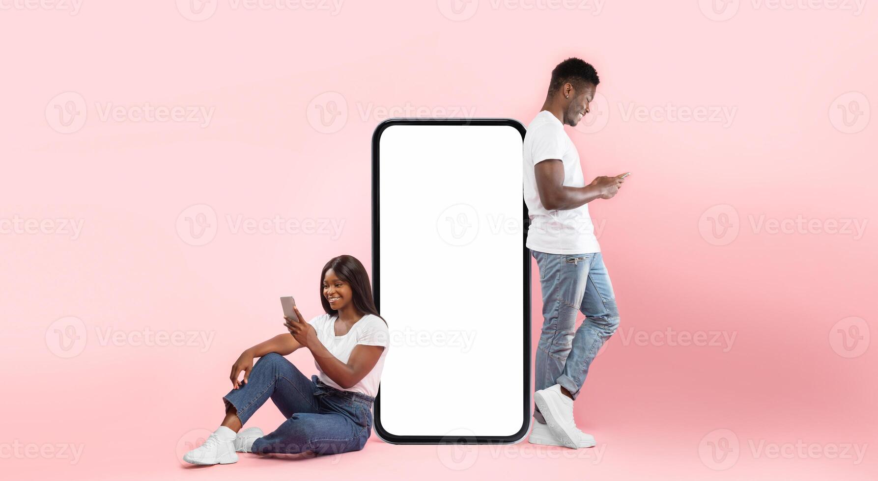 Modern Virtual Communication. Creative collage of young black couple leaning on big cell phone screen with blank white screen for mock up template, guy and lady chatting, sending and reading sms photo