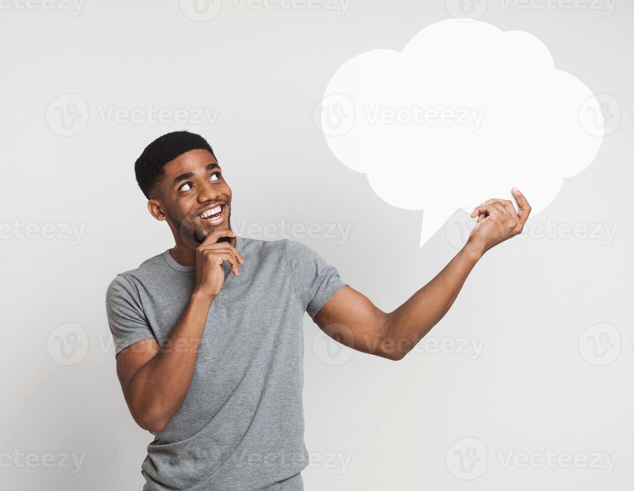 Hey, great idea. Happy pensive african-american man looking at blank speech bubble, copy space photo