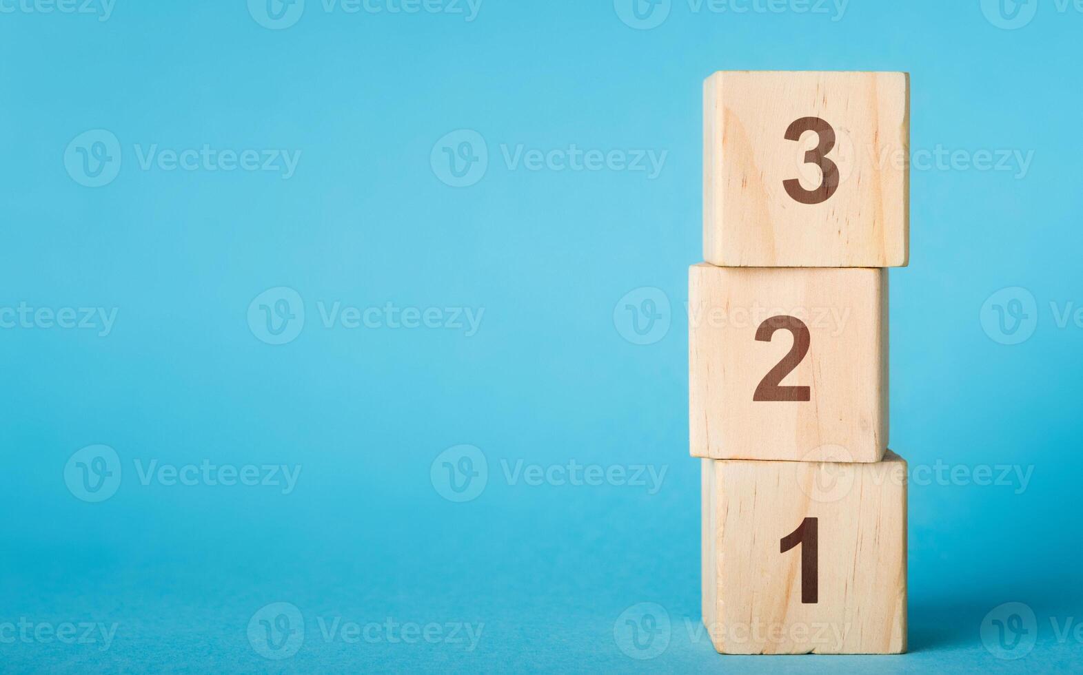 Wooden alphabet number blocks 123 on blue background, copy space photo