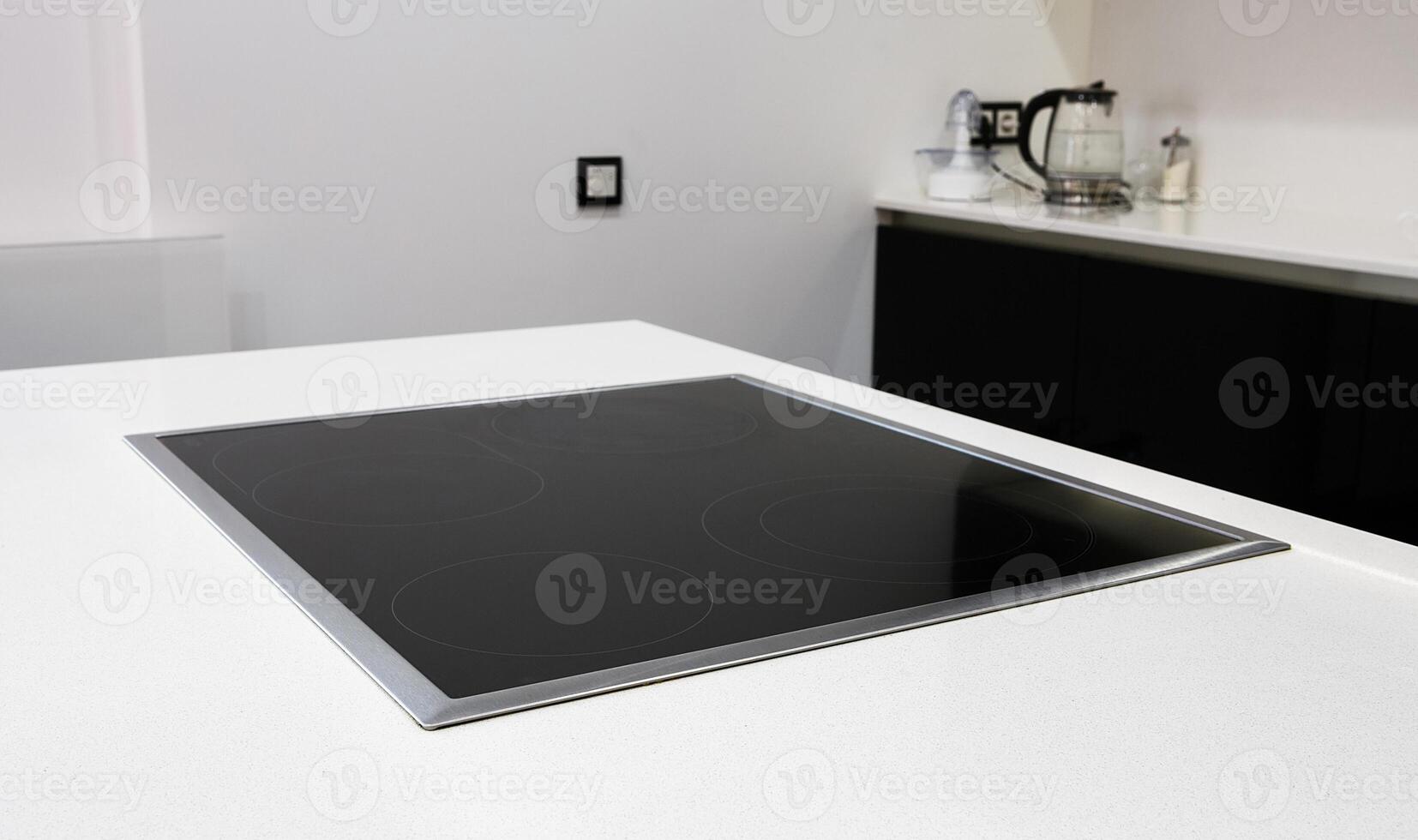 Modern black induction stove, cooker, hob or built in cooktop with ceramic top in white kitchen interior photo