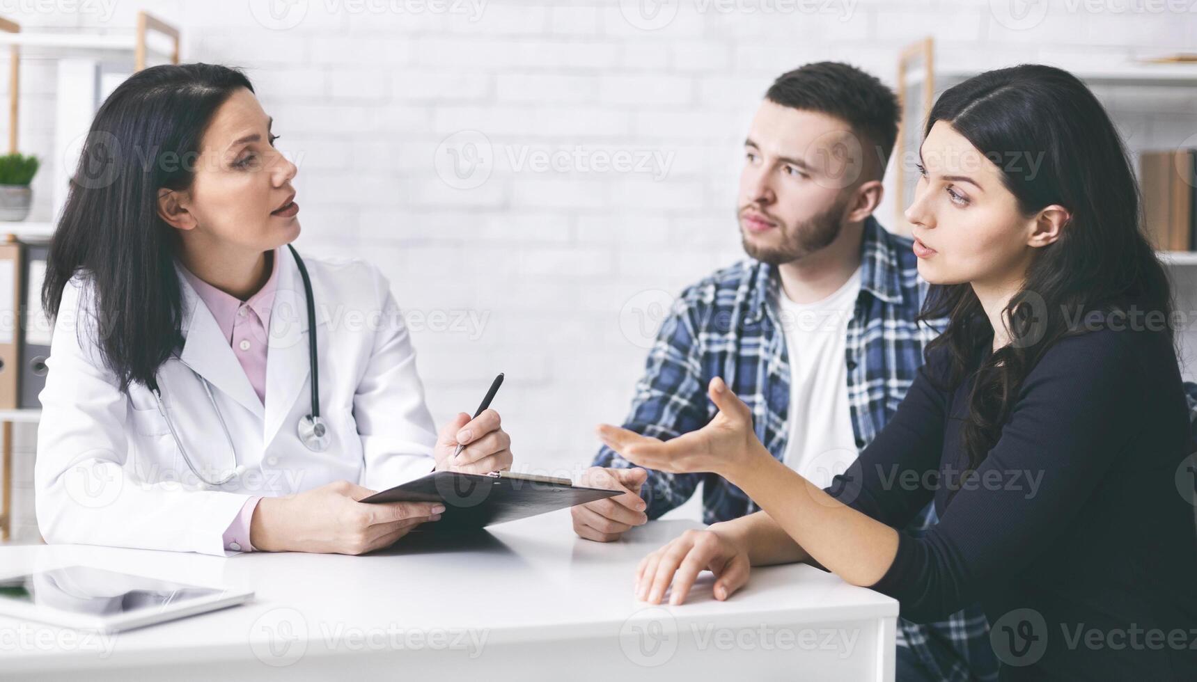 Attentive married couple listening to doctor prescriptions, asking about diagnosis, free space photo