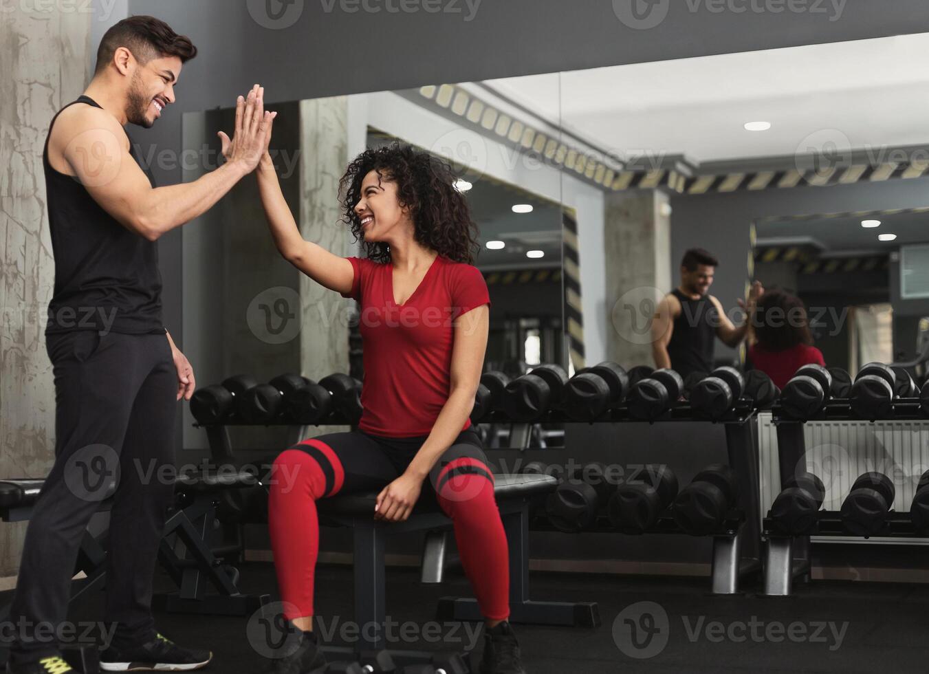 Successful training. Fitness trainer and woman giving each other high five after workout in gym, copy space photo