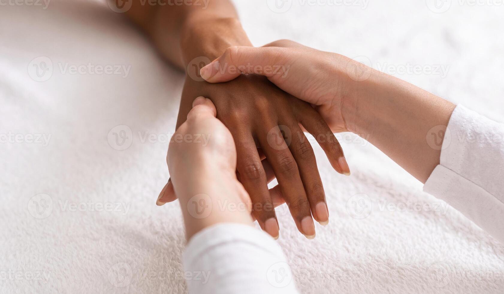 Masseuse making acupuncture hand massage for black woman at spa, view above, cropped photo