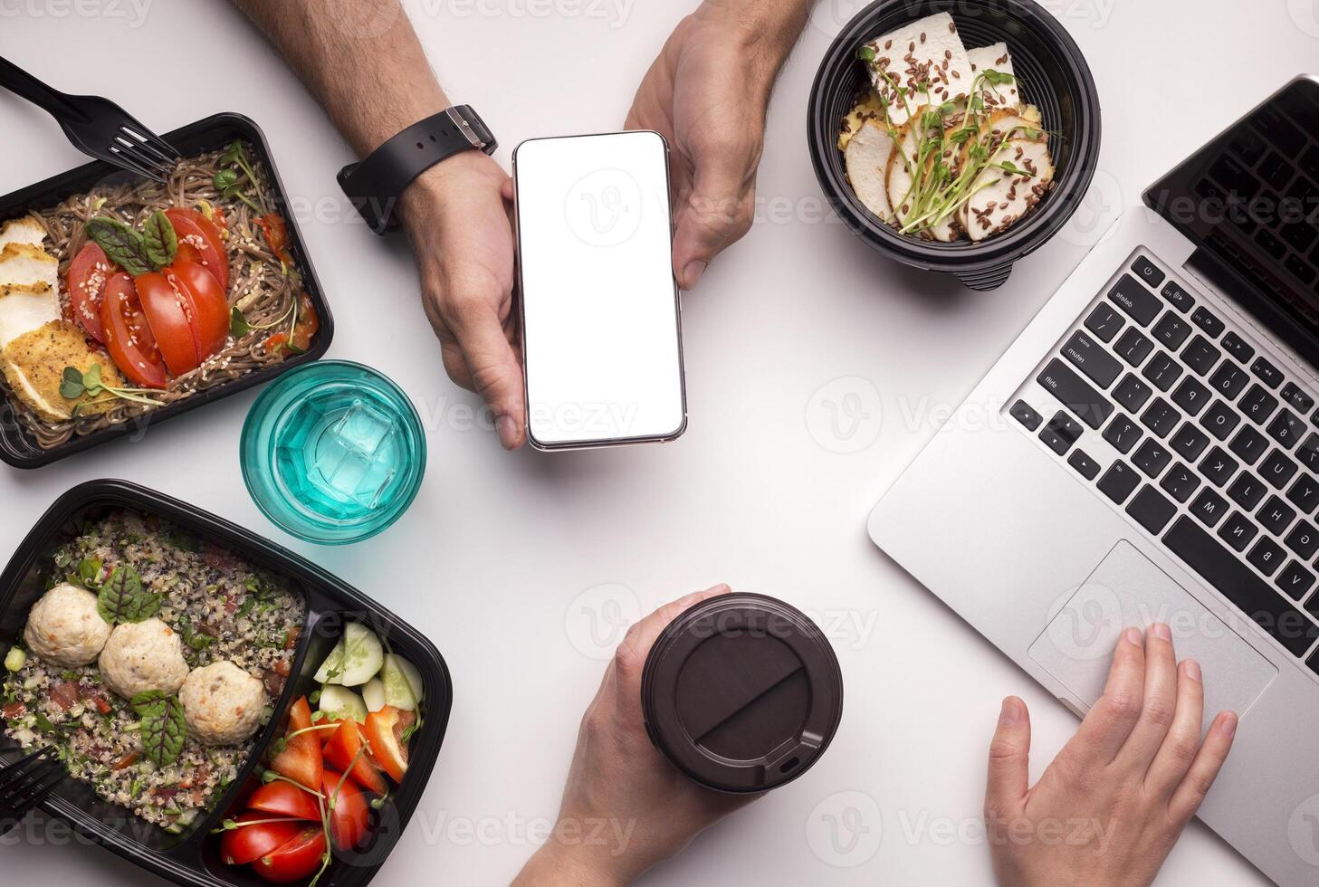 Food on workplace. Delivery of healthy food application in cellphone with white blank space on office table photo