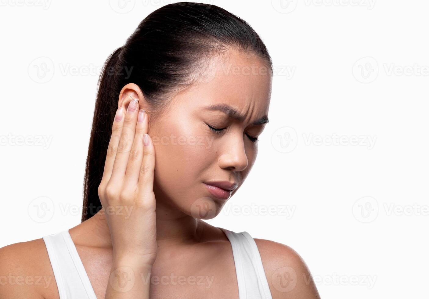Tinnitus, otitis, otalgia concept. Sie view of sick young asian female having ear pain, touching her painful head, panorama with copy space, white studio background, closeup photo