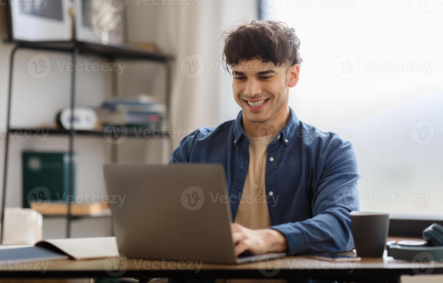 Happy Arabic Man Using Laptop Typing And Browsing Internet Sitting At Table In Office. Young Businessman Working Online On Computer At Modern Workplace. Entrepreneurship Concept photo