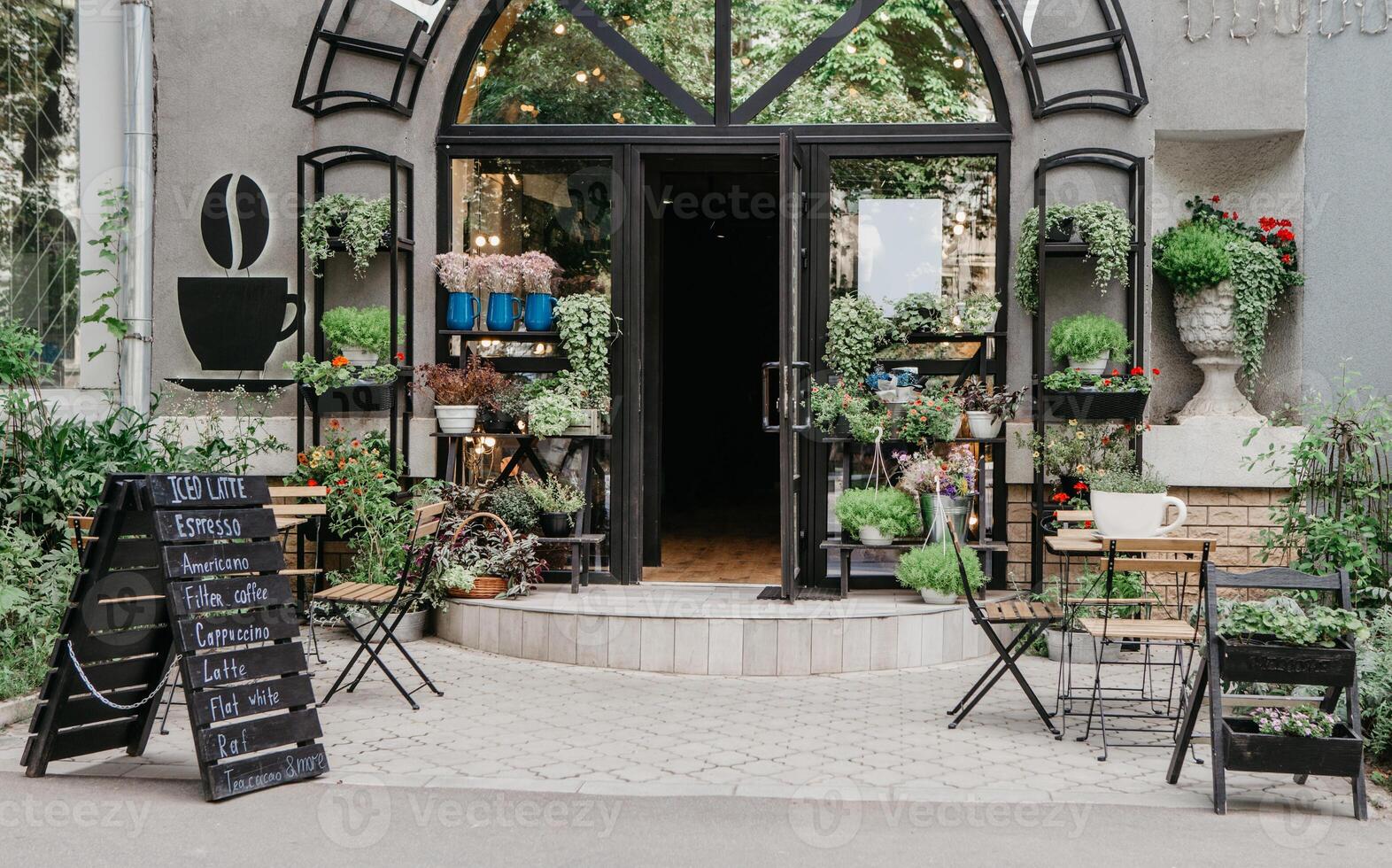 Eco cafe on street and flower studio, small business in city, reopening after covid-19, outdoor interior. Sign board with menu, tables for clients, potted plants on shelf at modern store, nobody photo
