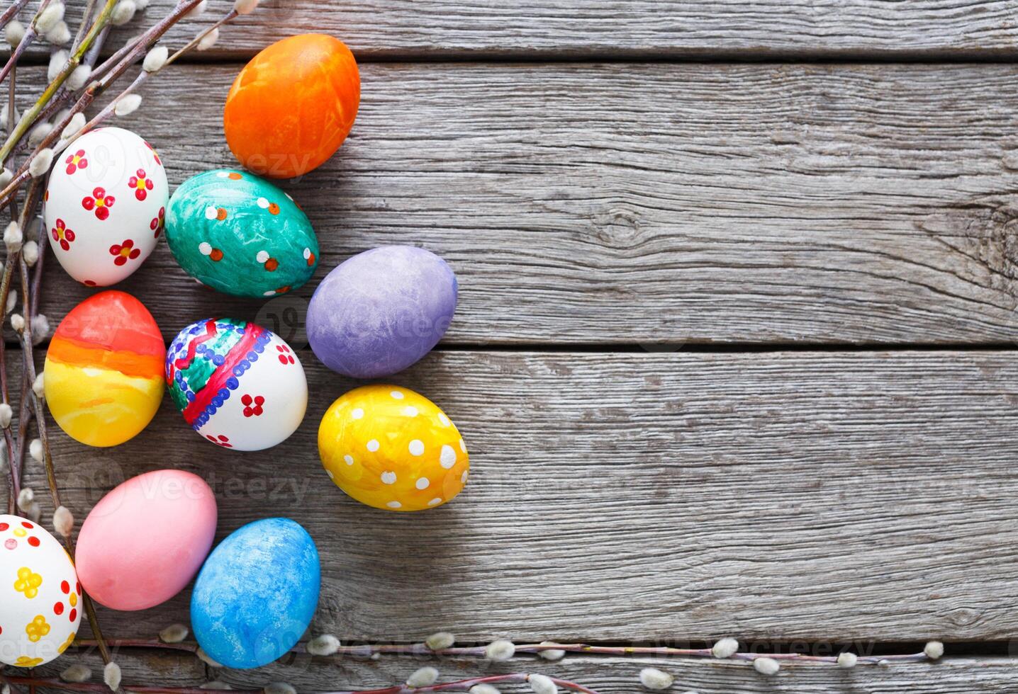 Handmade painted easter eggs on wood background. Colorful holiday decoration on rustic table top view with copy space photo