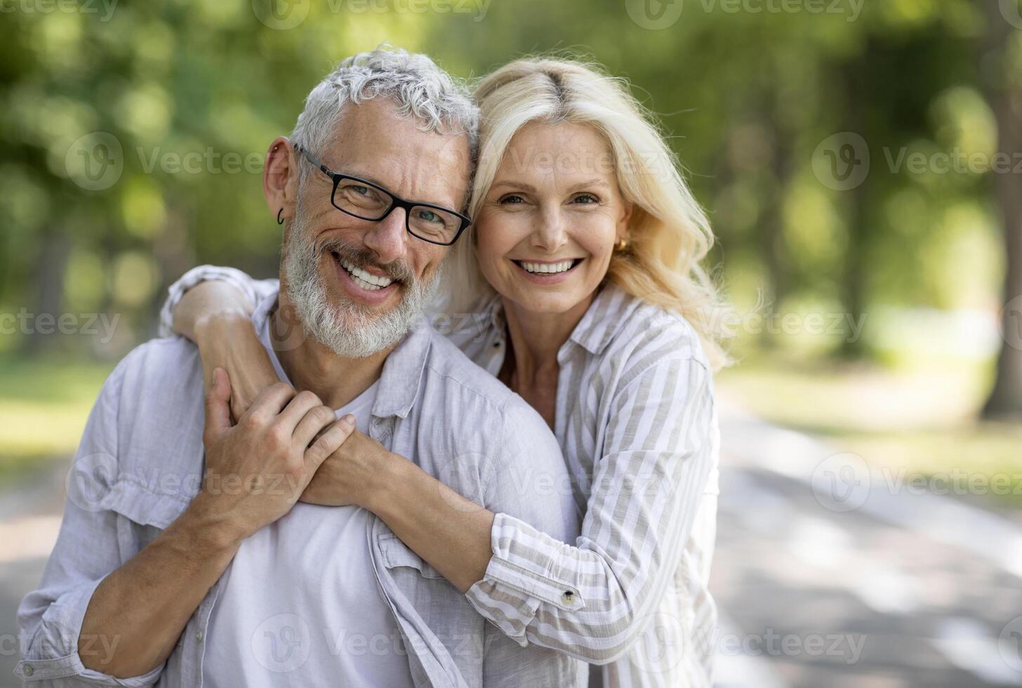Happy Mature Spouses. Portrait of cheerful older couple hugging and smiling at camera, joyful senior man and woman embracing while posing together outdoors, enjoying romantic date outside, closeup photo
