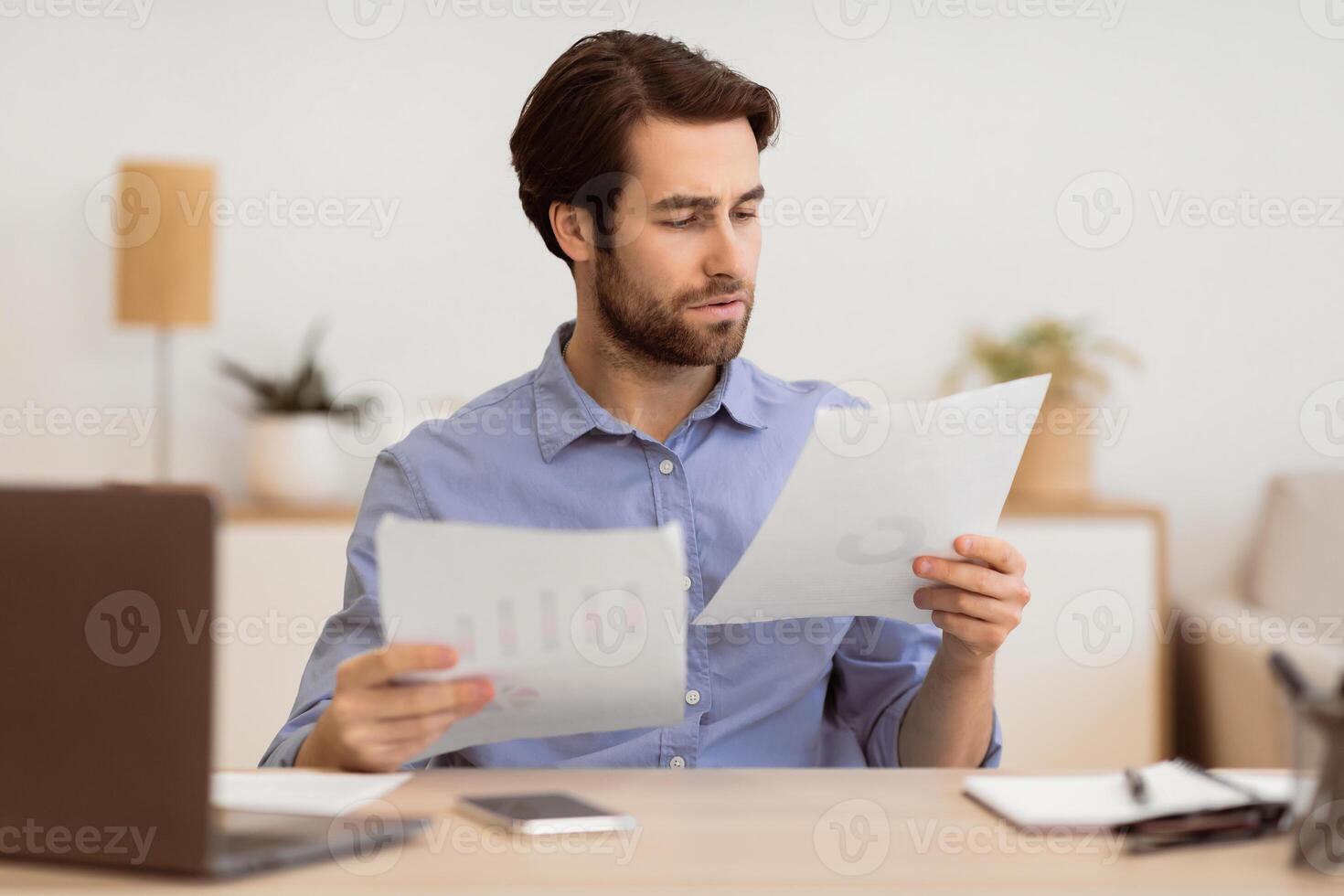 Serious Businessman Entrepreneur Looking Through Documents And Papers Reading Business Correspondence, Reports And Financial Bills Working Sitting In Modern Office. Selective Focus photo