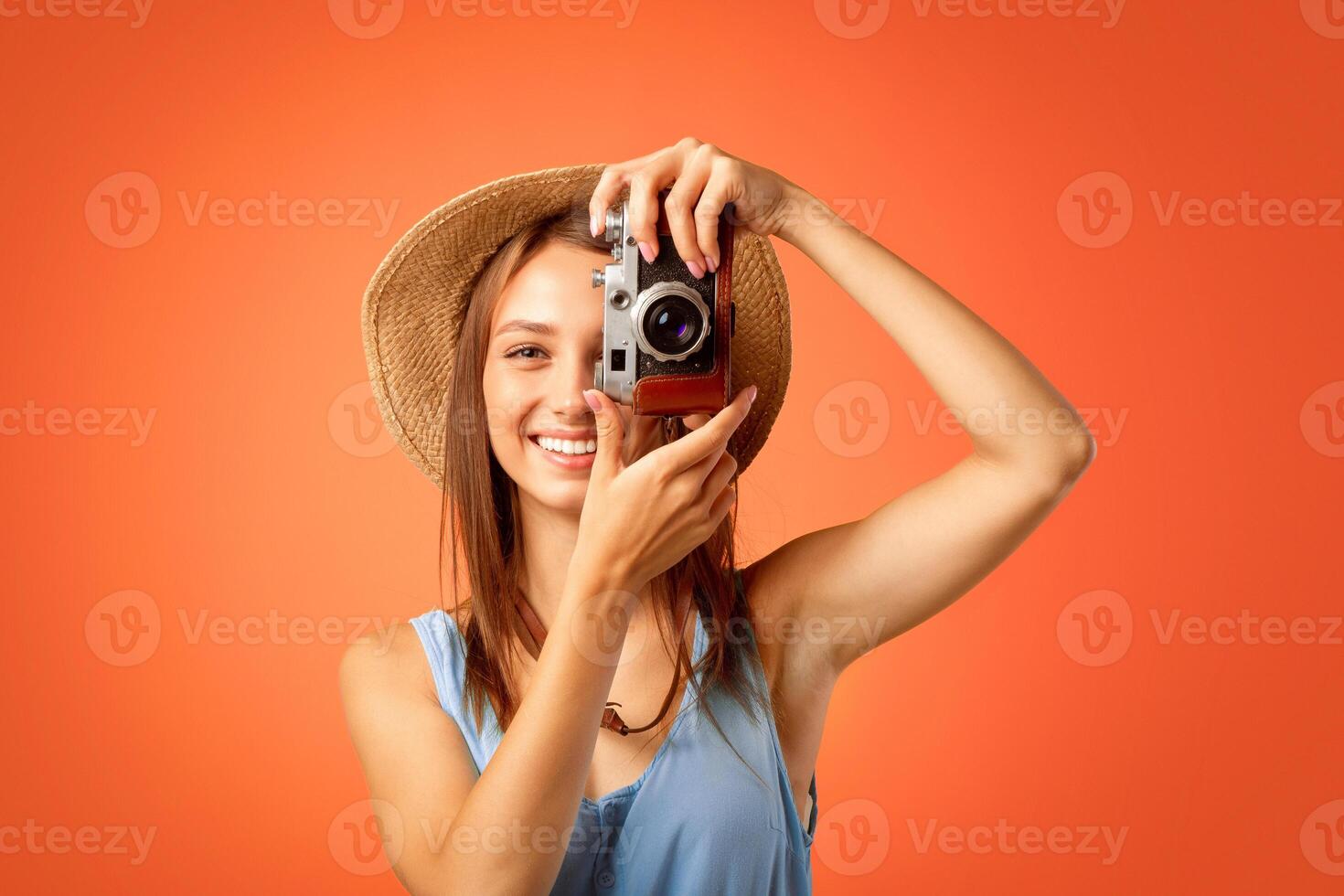 Cheerful girl photographer taking photos over yellow studio background
