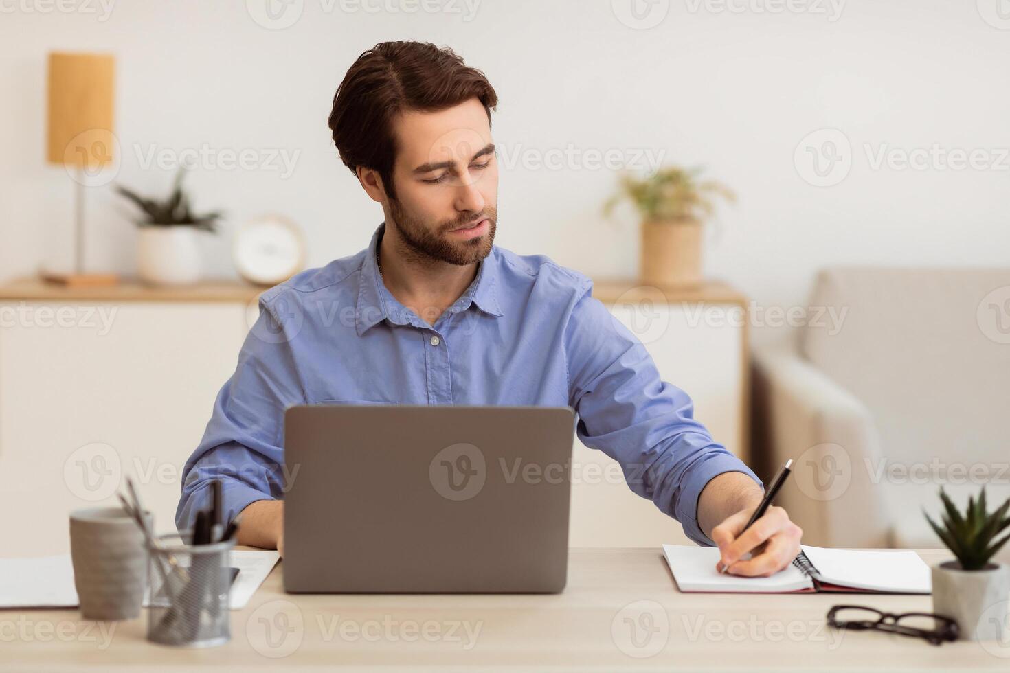 Business Career. Confident Entrepreneur Taking Notes Working At Laptop Computer Sitting In Modern Office. Businessman Posing At Workplace Concept. Selective Focus photo