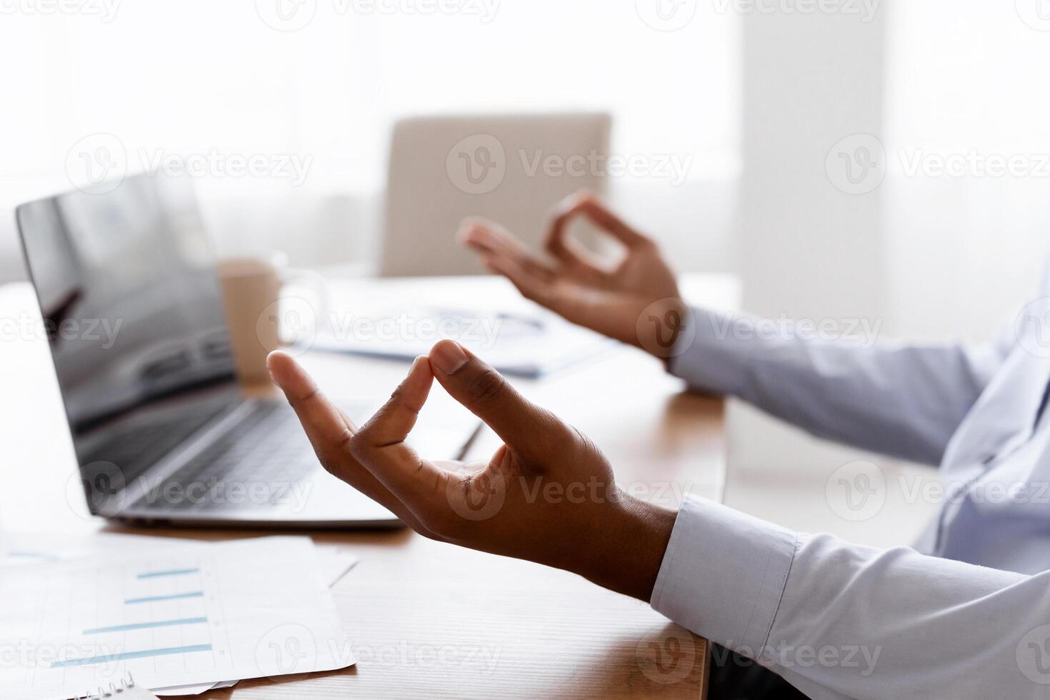 Cropped of african american man office worker sitting at workdesk with laptop, meditating, side view, copy space. Unrecognizable black manager relaxing during stressful working day photo
