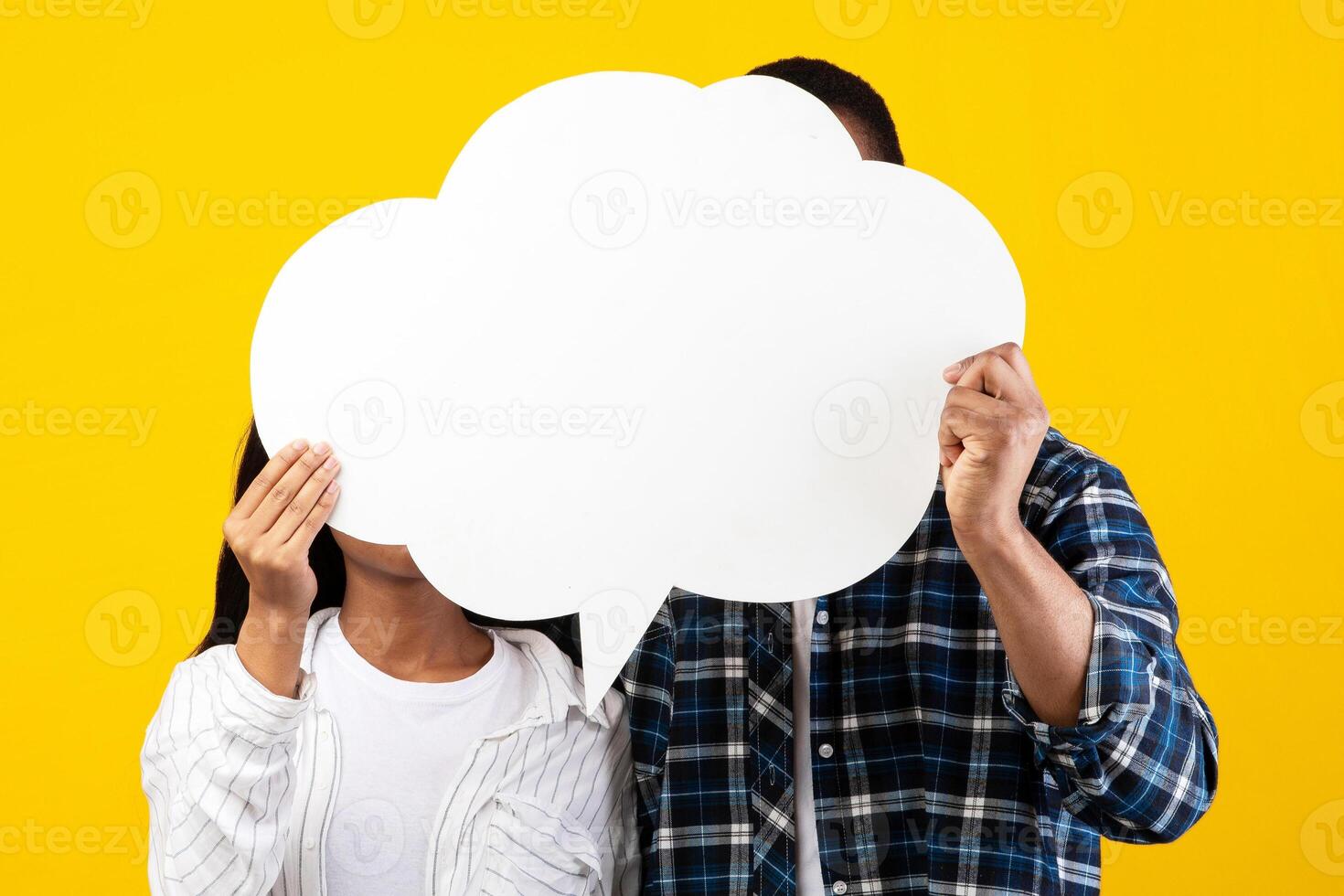 Love, romance and free place for words. Unrecognizable teen african american man and woman hold abstract bubble with empty space and hiding behind it, isolated on yellow background, studio shot photo
