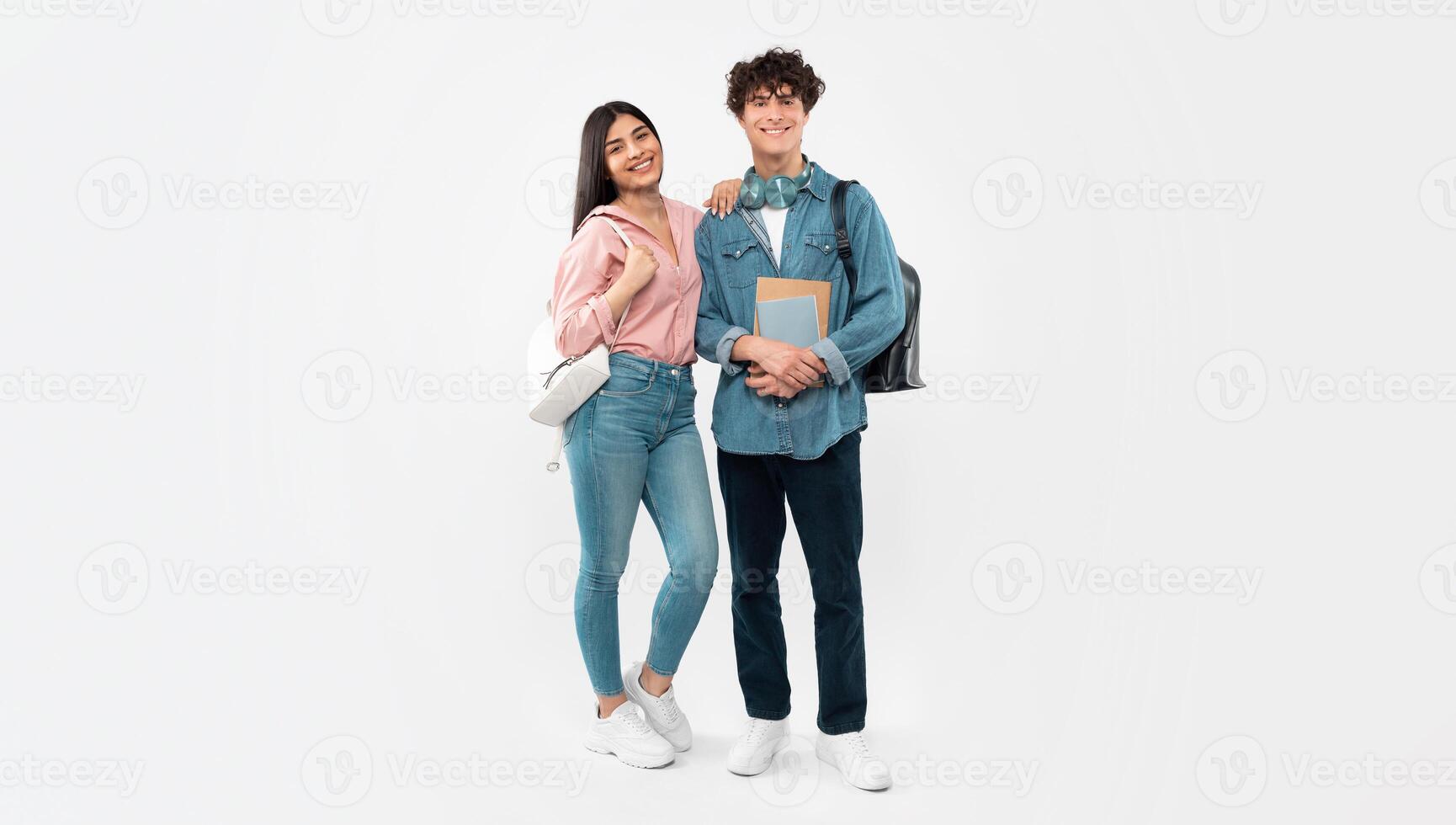 College Years. Full Length Shot Of Students Boyfriend And Girlfriend Posing Holding Textbooks And Backpacks On White Studio Background. Couple Of College Friends Smiling To Camera. Panorama photo