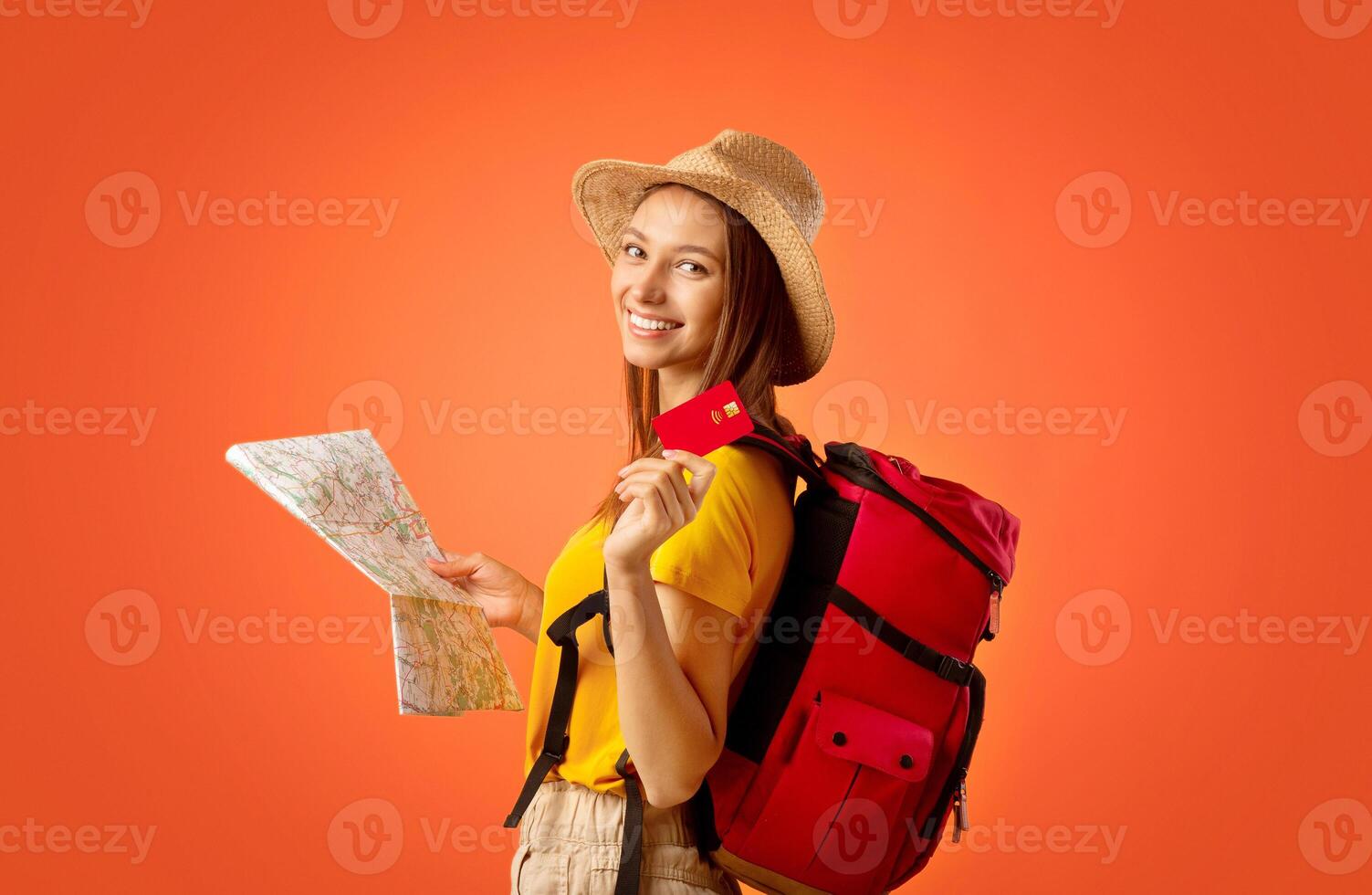 Girl backpacker with map holding credit card over yellow background, time to travel photo