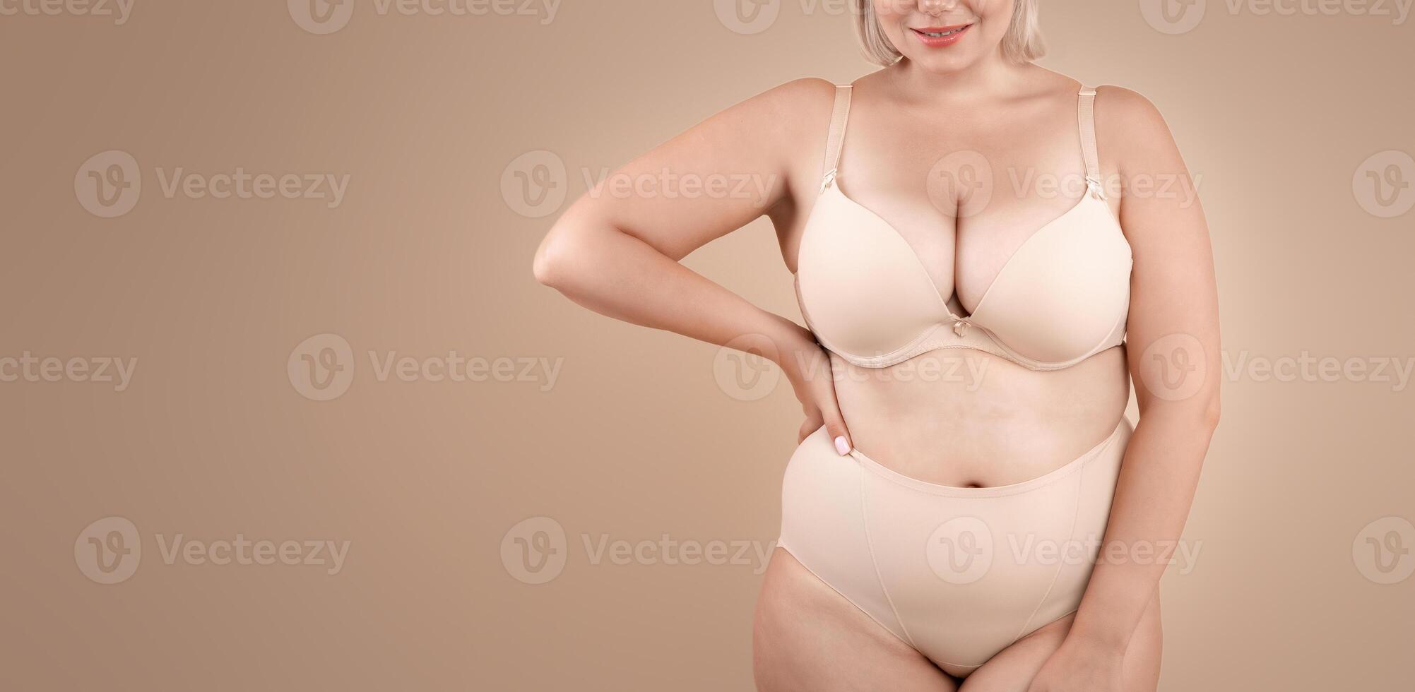 Self Acceptance. Beautiful Curvy Lady In Underwear Posing On Beige Background In Studio, Body Positive Plus Size Woman In Lingerie Enjoying Her Natural Beauty, Cropped Image With Copy Space photo