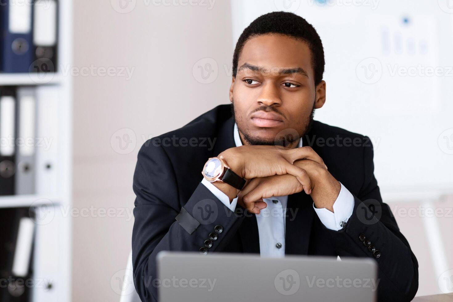 Upset african american businessman working with laptop in office, looking at copy space, suffering from problems with business. Crisis in business, financial difficulties, burnout at job concept photo