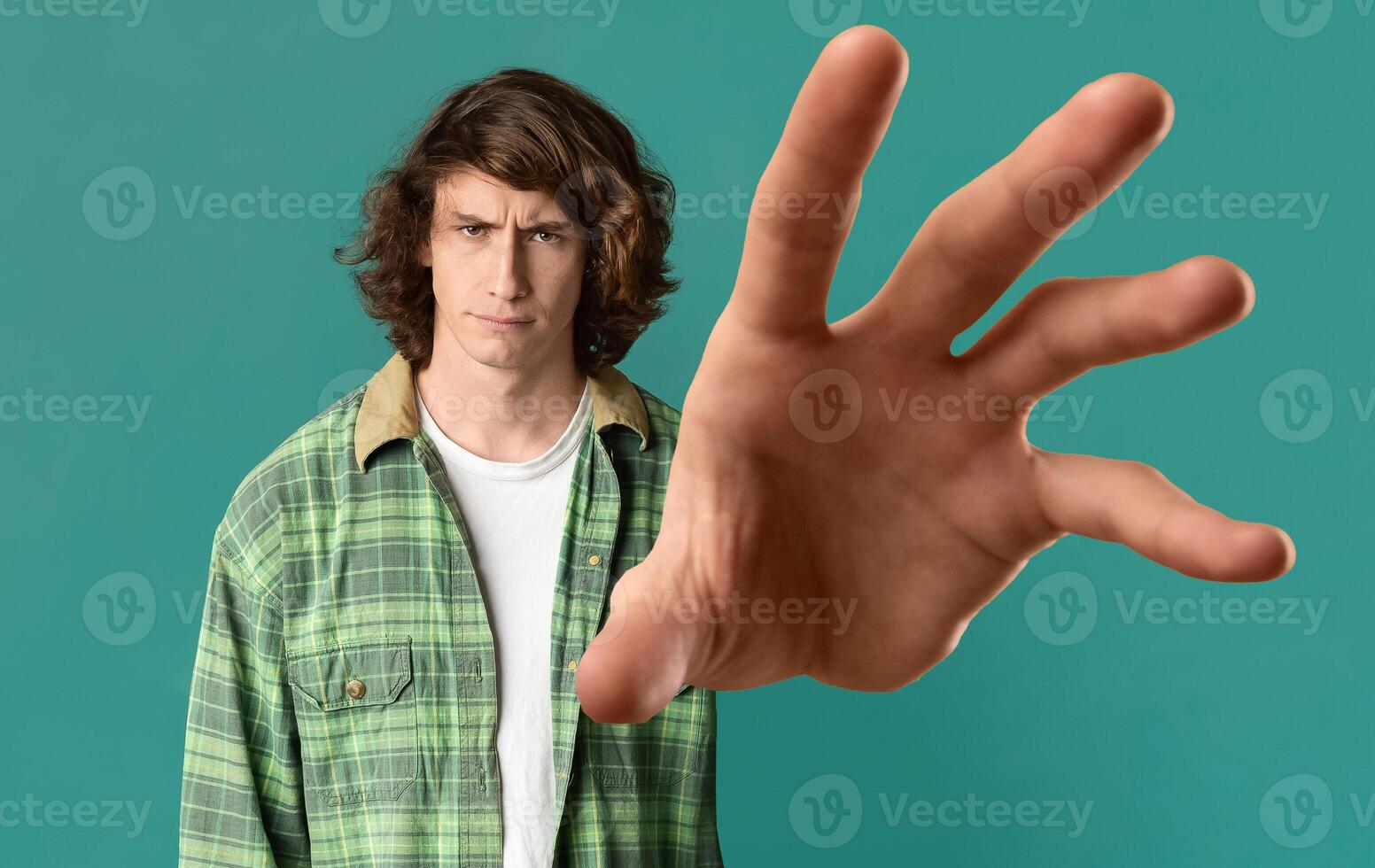 Give it to me. Young long-haired guy in casual outfit grabbing something on turquoise studio background, panorama, caucasian millennial man outstretching hand towards camera, creative image photo