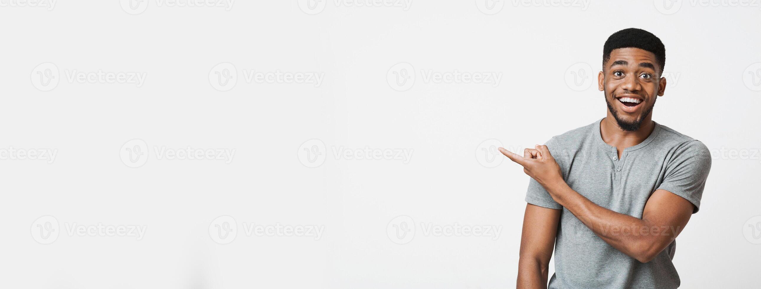 Unbelievable offer. Excited african american guy with open mouth pointing aside at empty space, panorama photo