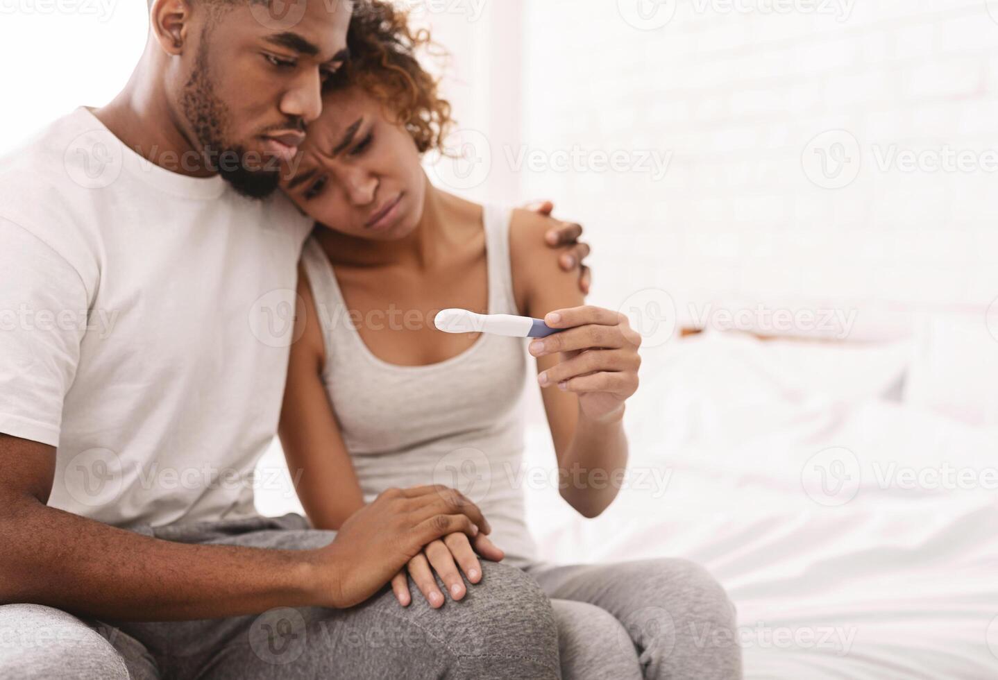 Infertility problem. Black couple sitting with negative pregnancy test result, free space photo