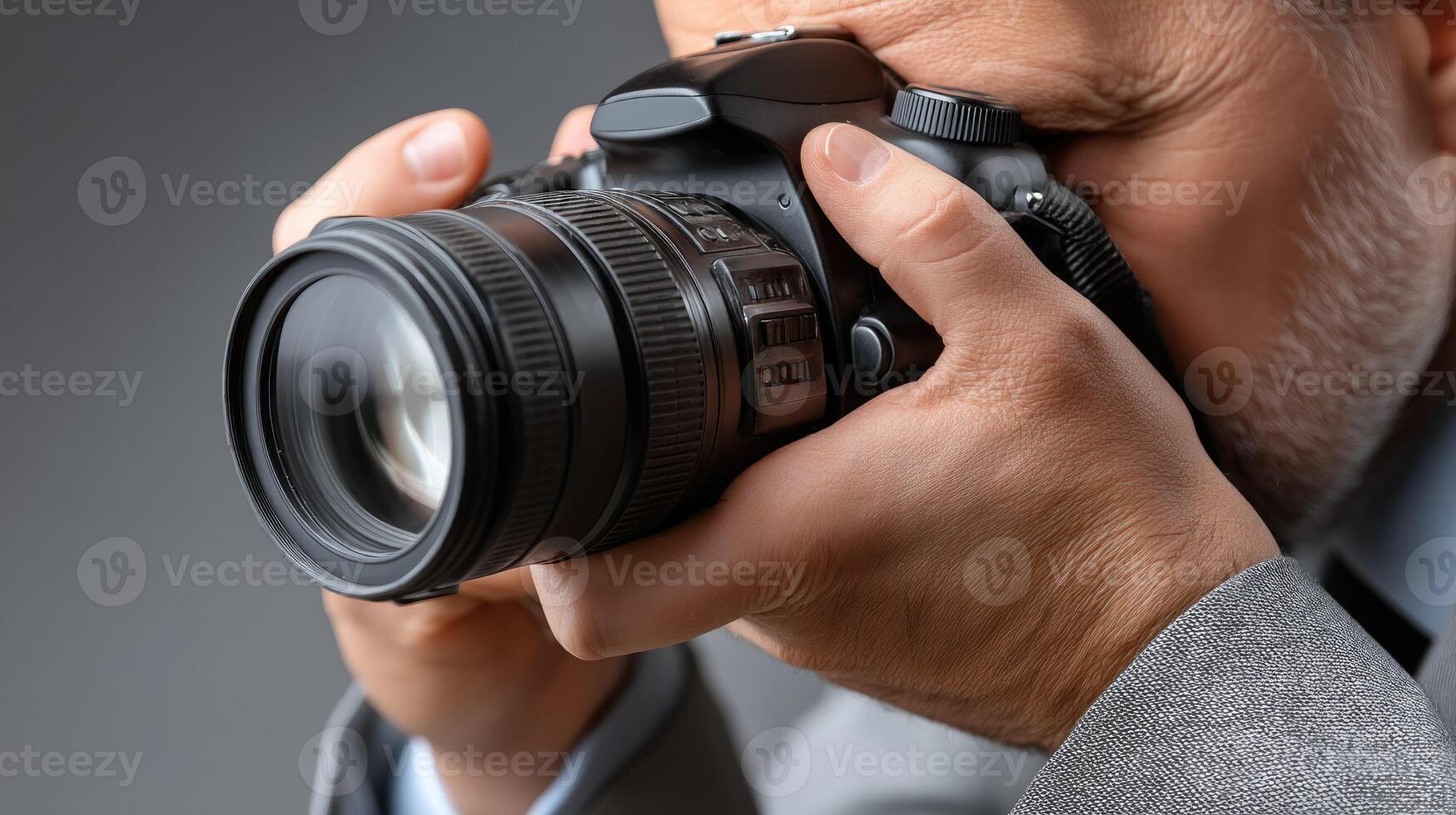 A man in a suit is holding a camera photo