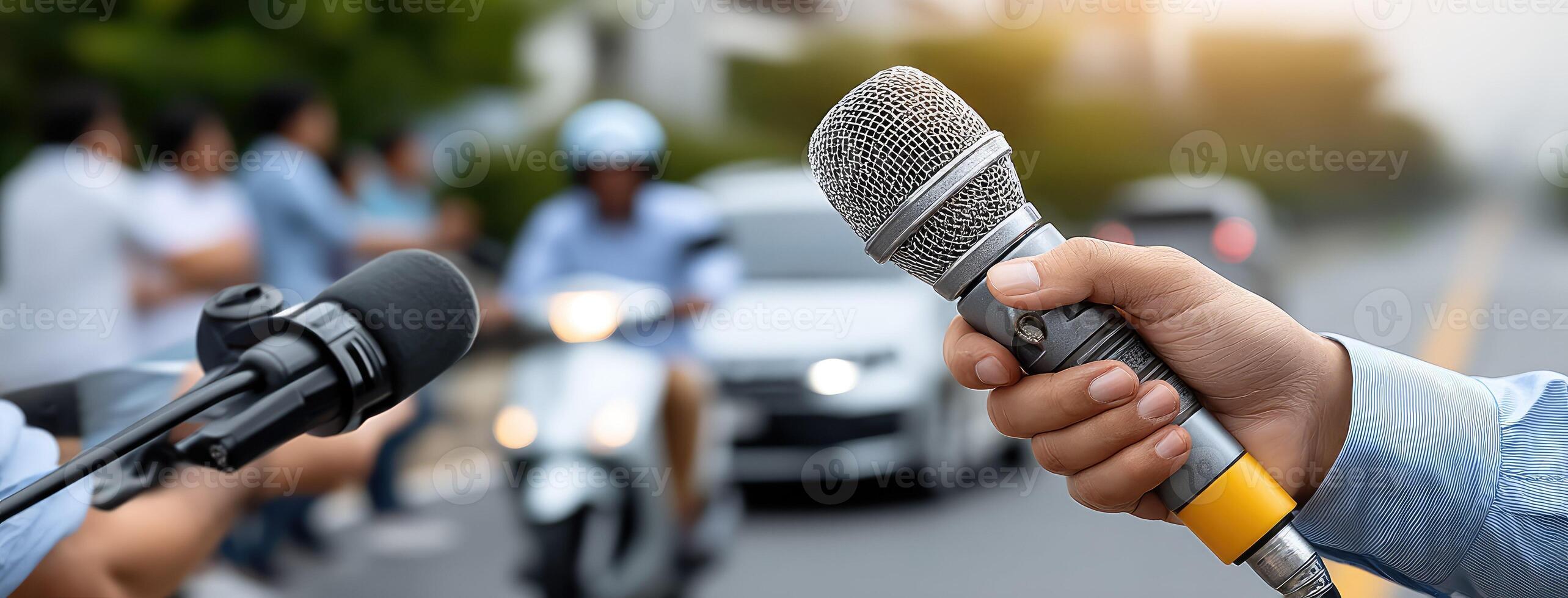 A person holding a microphone and microphone in front of a crowd photo