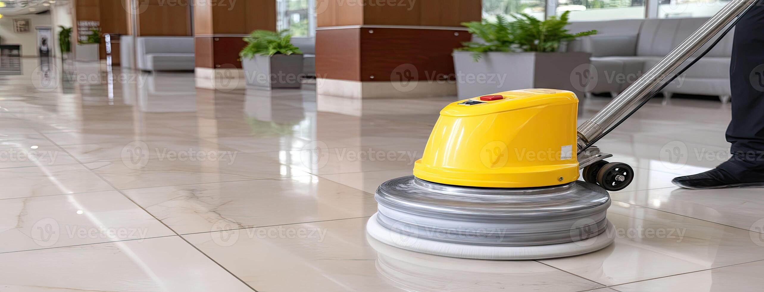 A man is cleaning a floor with a yellow machine photo