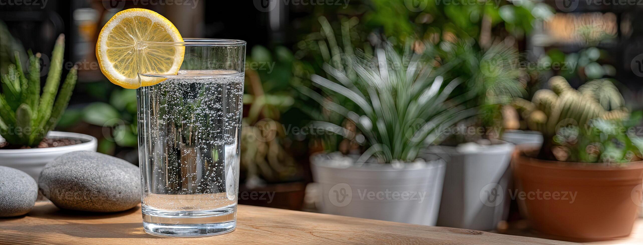 A glass of water with lemon on top of a table photo