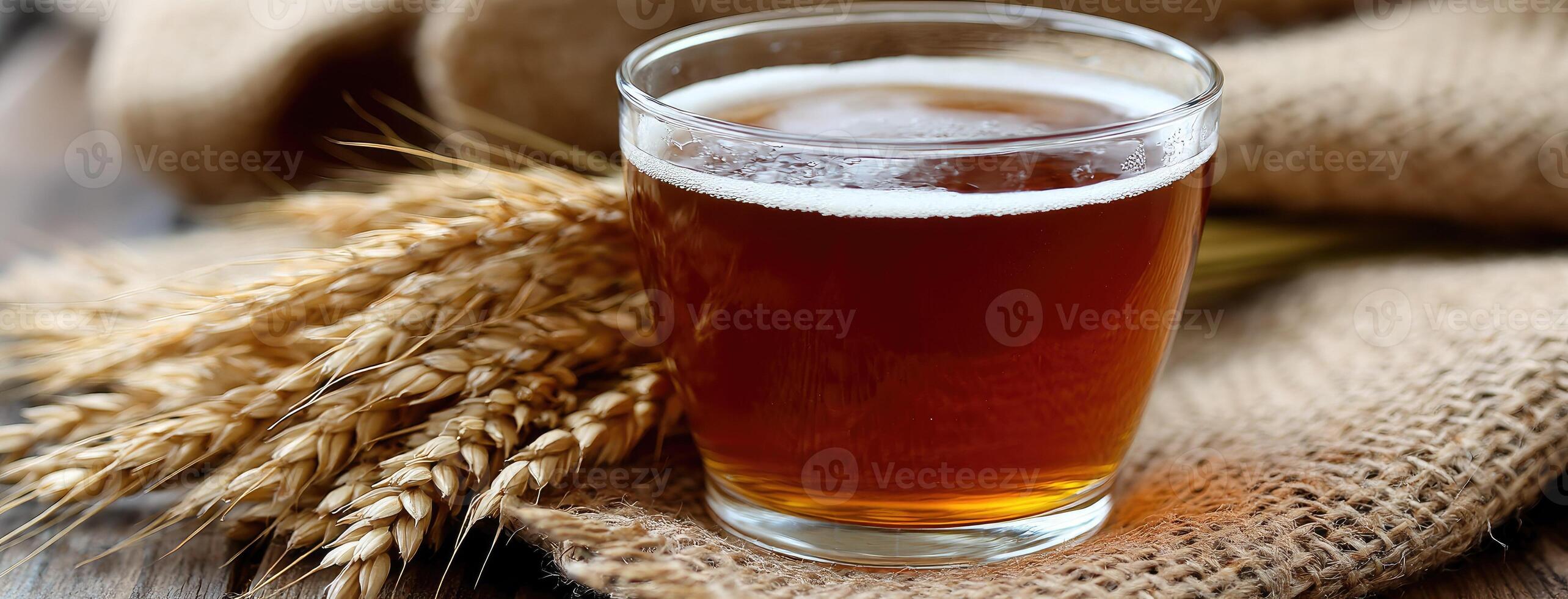 A glass of beer and some wheat on a table photo