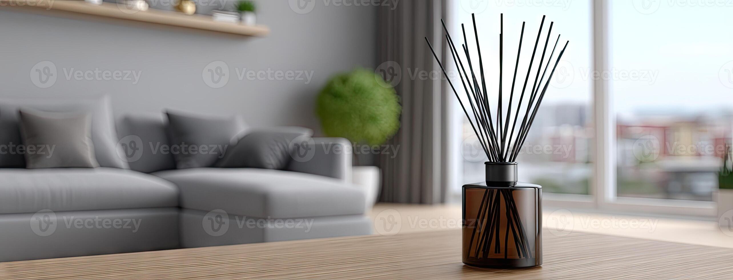 A vase with black sticks on a table in front of a couch photo