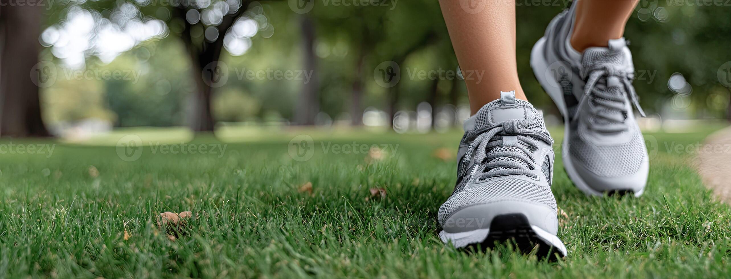 A person wearing a pair of running shoes on grass photo